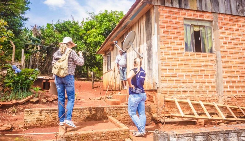 Duas pesquisadores sobrem escada improvisada para chegar à casa de morador rural (Foto: Nucom)