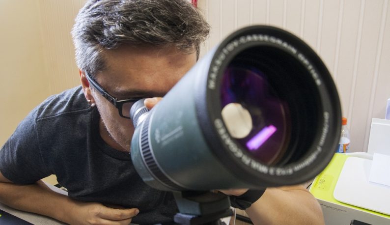 Prof. Daniel Brito de Freitas vendo através de um pequeno telescópio (Foto: Ribamar Neto/UFC)