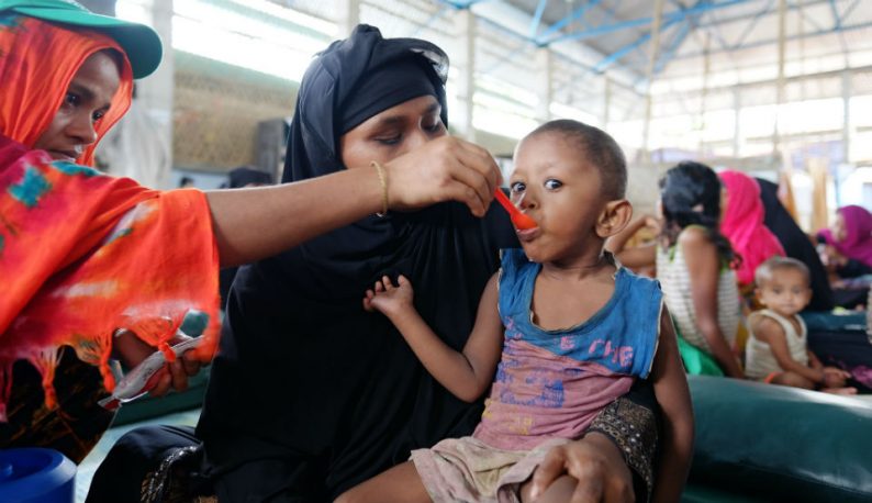 Criança com sinais de desnutrição sendo alimentada em uma área de refugiados localizada em Bangladesh (Foto: Mallika Panorat/União Europeia)