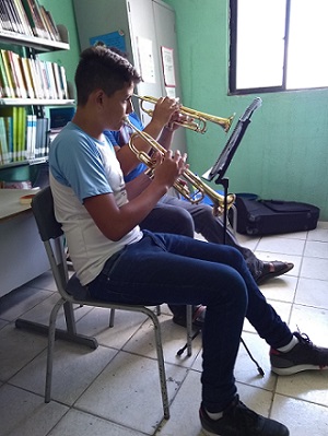 Menino estudante tocando trompete