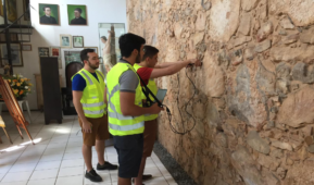 Pessoas utilizam equipamentos em parede de prédio histórico para análise