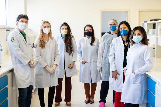 Equipe dos laboratórios reunidas: 7 cientistas (apenas um homem) enfileirados posando para a foto no ambiente de laboratório
