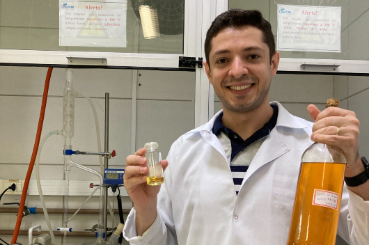 Foto de pesquisador segurando o óleo e o lubrificante de pequi