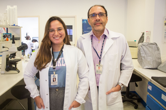 Pesquisadores de jaleco no laboratório