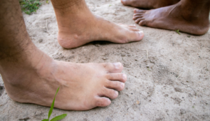 Imagem de pés descalços sobre a areia