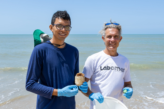 O Prof. Tommaso Giarrizzo e o doutorando do Programa de Pós-Graduação em Ciências Marinhas Tropicais (PPGCMT) do Labomar Lucio Brabo seguram resíduos plásticos na praia