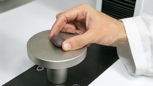 Imagem de um briquete sobre um aparelho do laboratório