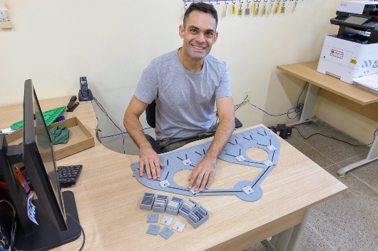 Imagem: foto do inventor do dispositivo manuseando-o sobre uma mesa