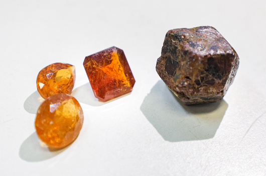 Imagem: minerais do tipo grossulária dispostos sobre uma mesa