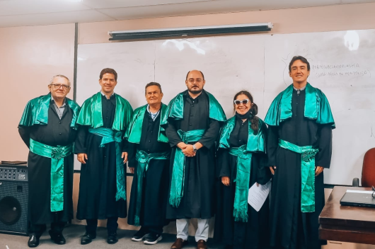 Pesquisadores usando veste talar durante defesa de doutorado