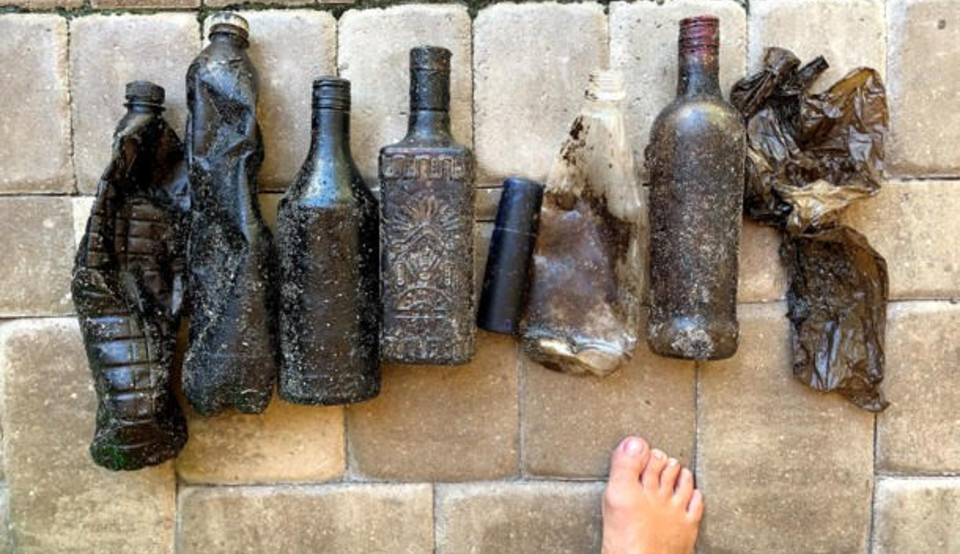 Imagem de diversas garrafas cobertas de óleo no chão