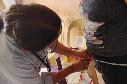 Profissional tirando medidas de uma mãe