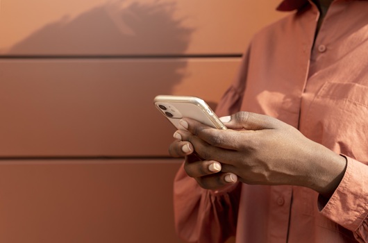 Fotografia em close de mãos de uma mulher usando um smartphone (Foto: Magnific)